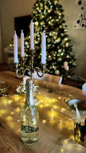 a table with candles and a christmas tree with lights at No.8: Lovely & Cosy 3-room Heart of the City in Timişoara