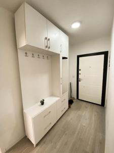 a room with white cabinets and a large door at City Center Apartment in Ferizaj