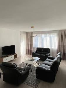 a living room with two couches and a television at City Center Apartment in Ferizaj