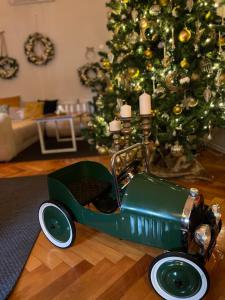 a green toy car sitting in front of a christmas tree at No.8: Lovely & Cosy 3-room Heart of the City in Timişoara