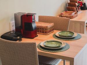 a table with a coffee maker and plates on it at Apartamento em Barra Grande, Piauí in Cajueiro