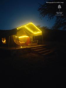 a tent lit up at night with lights at Oseki Maasai Mara Camp in Narok