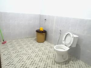 a bathroom with a toilet and a trash can at Semar88 Guest House in Balong