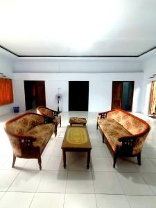 ein Wohnzimmer mit Sofas und einem Couchtisch in der Unterkunft Semar88 Guest House in Balong