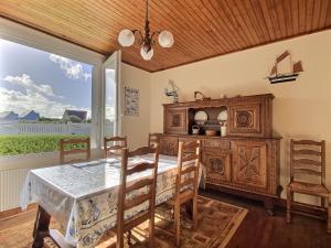 een eetkamer met een tafel en een groot raam bij Maison d'Ys à 500 m de la plage in Saint-Nic