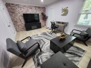 ein Wohnzimmer mit Stühlen, einem TV und einem Sofa in der Unterkunft Modern Island Serenity!-Pet-Friendly villa in Hilton Head Island