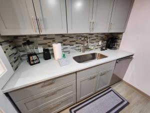 una cocina con armarios blancos y fregadero en Modern Island Serenity!-Pet-Friendly villa, en Hilton Head Island