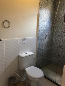 uma casa de banho com um WC e uma cabina de duche em vidro. em Le Marchand de Sable- Suites e apartamento em Búzios