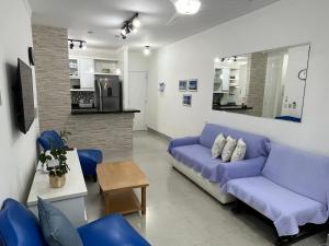 sala de estar con sofá azul y mesa en APTO RIVIERA 2 DORMS COM AR A 180 m DA PRAIA ! APROVEITE AS BAIXAS TARIFAS DE MAIO ! CONSULTE !, en Riviera de São Lourenço