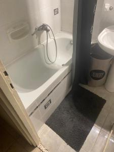 a bathroom with a bath tub and a sink at Ögünc’s Apartment in Szeged