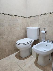 a bathroom with a white toilet and a sink at Alojamientos Estrellas Azules in Colón