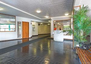 um corredor com um banco e plantas num edifício em Royal Aloha em Honolulu