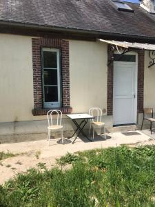 una mesa y sillas frente a un edificio en Maison à la campagne pour 7 pers, wifi et parking en Aube-sur-Rîle