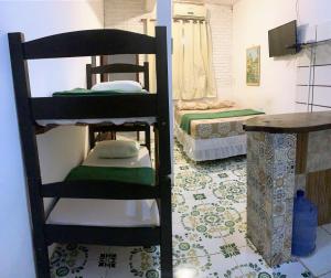 a room with two bunk beds and a table at Planeta Verde Apartamentos in Itacaré