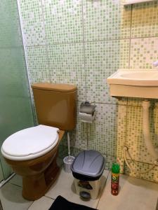 a bathroom with a toilet and a sink at Planeta Verde Apartamentos in Itacaré