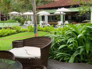 a wicker chair sitting on a table in a garden at Apto.luxo superaconchegante 4 pessoas 1vaga garage in Angra dos Reis