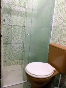 a bathroom with a toilet and a shower at Planeta Verde Apartamentos in Itacaré