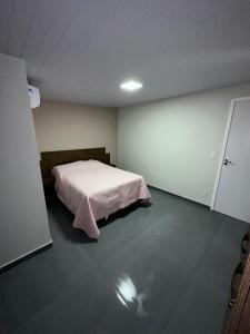 Residencial Wrubleski SC في بينيرا: غرفة نوم بسرير وبطانية وردية