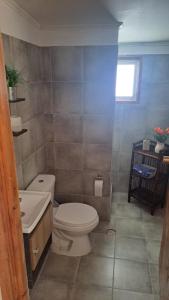 uma casa de banho com um WC branco e um lavatório. em Casa Algarrobo em Algarrobo