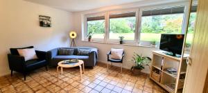 ein Wohnzimmer mit einem Sofa und einem TV in der Unterkunft Ferienwohnung Auszeit in Glüsingerlohe