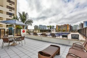 a balcony with a table and chairs and a swimming pool at Flat Particular no Comfort Suites in Brasilia