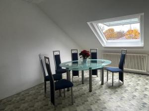 een eetkamer met een glazen tafel en stoelen bij GardenApartment in Frankfurt am Main