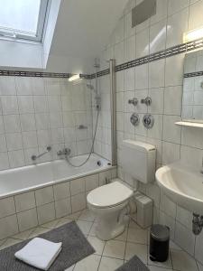 een badkamer met een toilet, een bad en een wastafel bij GardenApartment in Frankfurt am Main