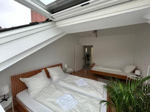 een slaapkamer op zolder met een bed en een raam bij GardenApartment in Frankfurt am Main