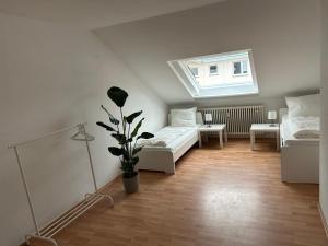 una piccola camera con due letti e una finestra di GardenApartment a Francoforte sul Meno