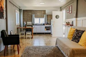 a living room with a couch and a kitchen at Studio 307 - Próximo ao centro de São Francisco de Paula in São Francisco de Paula