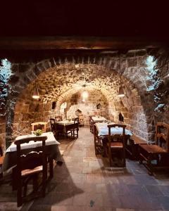 a restaurant with tables and chairs in a stone tunnel at Il Viterbino Struttura convenzionata con impianti termali in Viterbo