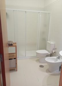 a white bathroom with a toilet and a shower at Casas Marias de Portugal - Cerveira in Vila Nova de Cerveira