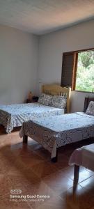 sypialnia z 2 łóżkami i oknem w obiekcie Rancho Belo w mieście São José da Barra