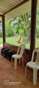 duas cadeiras brancas sentadas em frente a uma janela em Rancho Belo em São José da Barra