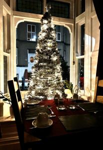 a christmas tree in a dining room with a table at Caer Menai in Caernarfon