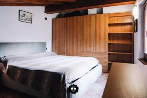 - une chambre avec un lit et une armoire en bois dans l'établissement Flat Fantoni 61, à Alzano Lombardo
