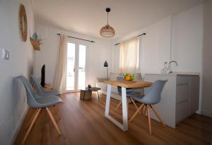 cocina y comedor con mesa y sillas en Lavendel Apartments, en Colonia de Sant Jordi