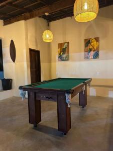 瓜皮米林的住宿－Sítio com piscina e churrasqueira，一个带两个灯的房间的一张台球桌