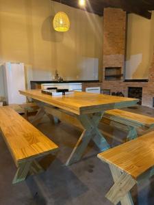 een grote houten tafel met banken in een keuken bij Sítio com piscina e churrasqueira in Guapimirim
