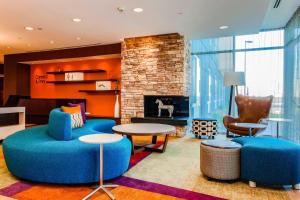 Elle comprend un salon doté d'un mobilier bleu et d'une cheminée. dans l'établissement Fairfield Inn & Suites by Marriott Pecos, à Pecos