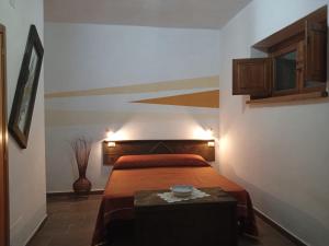 a bedroom with a bed and a table in it at Bed And Breakfasts LA CASETTA in Terranova di Pollino
