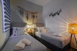TriovasálosにあるMavromata's Cozy Apartmentのランプ2つとランプ1つが備わるドミトリールームのベッド2台分です。