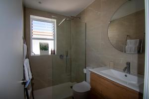 a bathroom with a shower and a sink and a mirror at Lavendel Apartments in Colònia de Sant Jordi