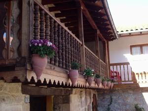 un balcón con macetas en el lateral de un edificio en El Espesedo, casa rural montañesa, en Argomilla