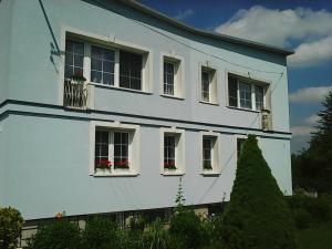 a white house with windows and flower boxes at La Casa De Roland in Wieliczka