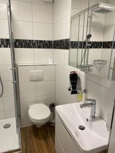 a white bathroom with a toilet and a sink at Paris3 in Oberhausen