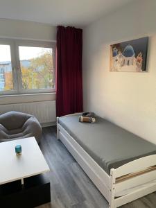 ein kleines Zimmer mit einem Bett und einem Stuhl in der Unterkunft Paris3 in Oberhausen