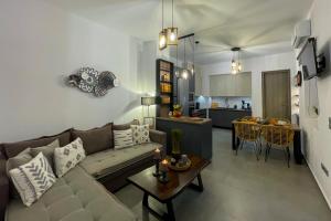 a living room and kitchen with a couch and a table at Mavromata's Cozy Apartment in Triovasálos
