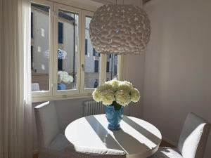 a dining room table with a vase of flowers on it at The window on the theatre and the cathedral - Luxury apartment in Como