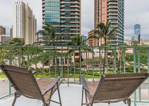 two chairs on a balcony with a view of a city at Royal Aloha Waikiki Beach in Honolulu